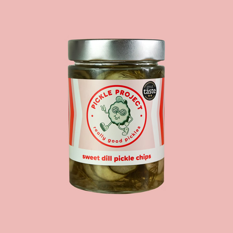Jar of Pickle Project sweet dill pickle chips on a pink background