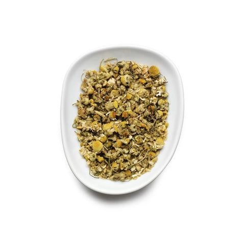 Dried herbs on a white plate with a white background