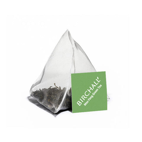 Tea bag with a green label on a white background