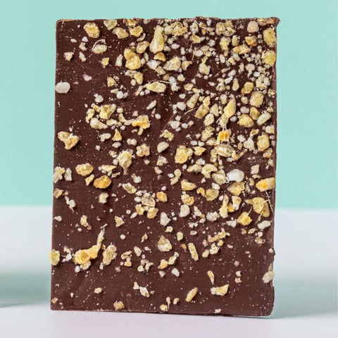 Chocolate bar with crumbly topping on a light blue background
