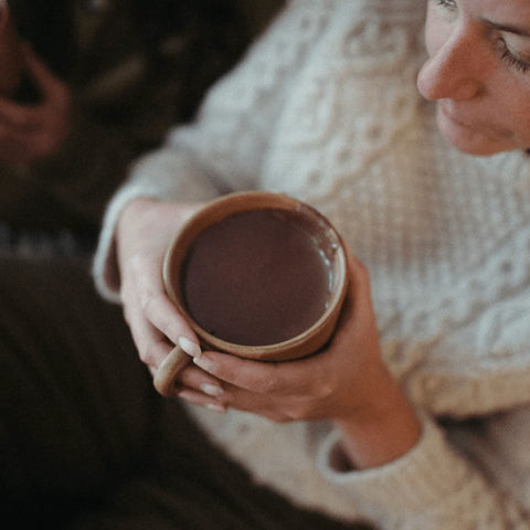 person holding a mug of harth hot chocolate