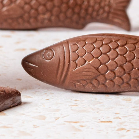 Chocolate fish-shaped candies on a light surface
