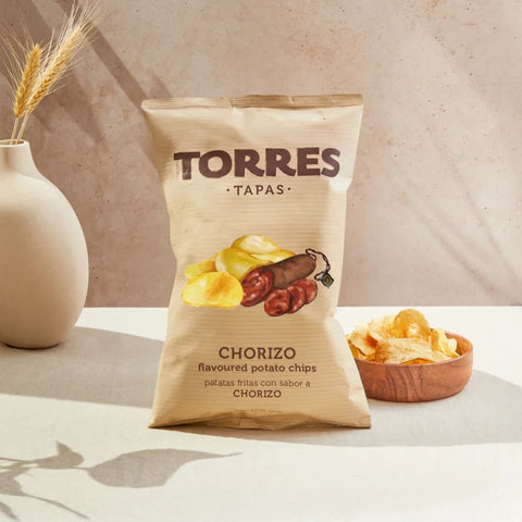 A bowl of crisps next to a packet of torres chorizo flavour