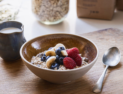 Bowl of cereal with fruits on a wooden table