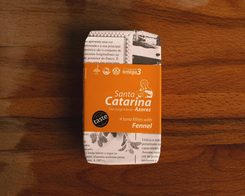 a tine of tuna with fennel on a wooden table